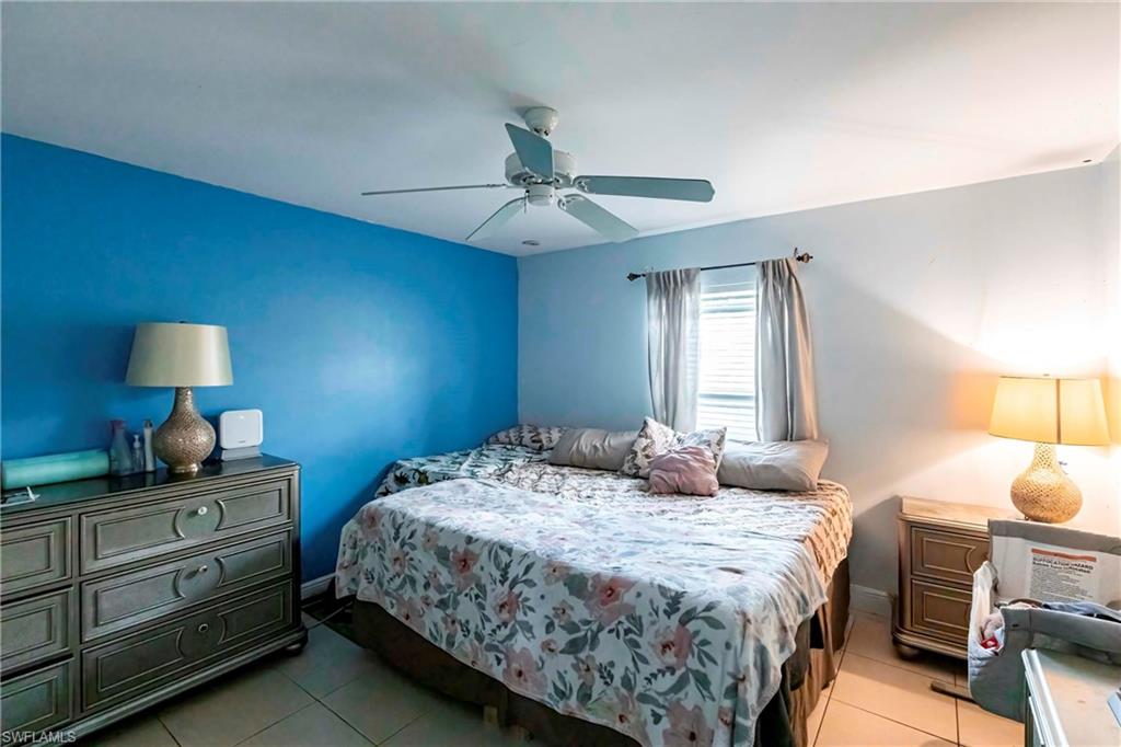 2900 8th Street Southwest Lehigh Acres, FL 33976 - Photo 15 of 32 a bedroom with a bed a lamp and a chandelier