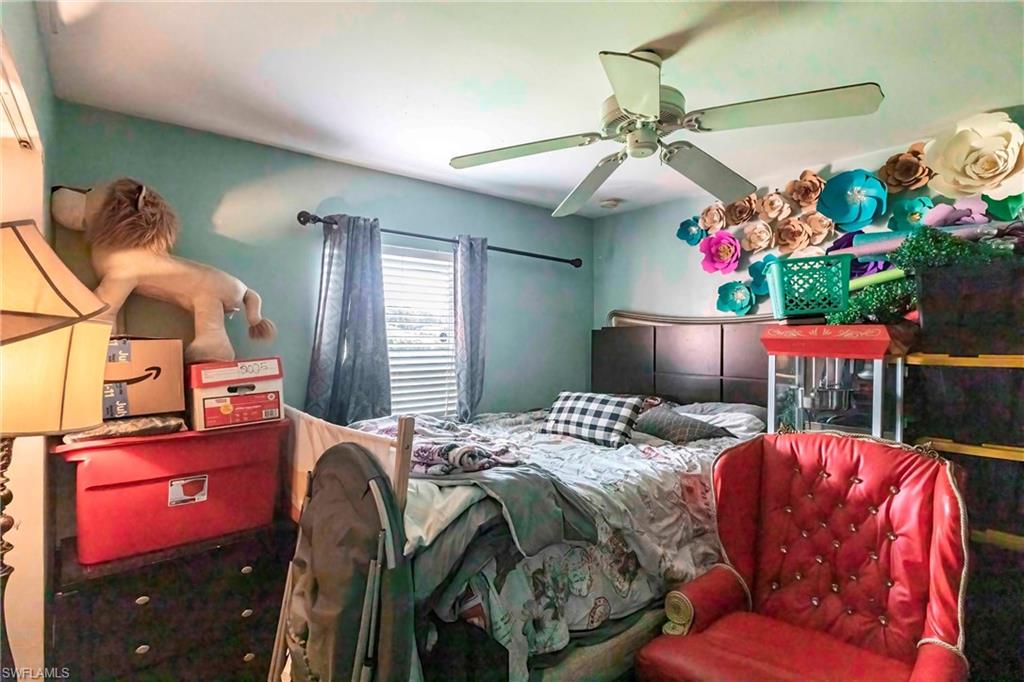 2900 8th Street Southwest Lehigh Acres, FL 33976 - Photo 20 of 32 a bedroom with bed and a chandelier