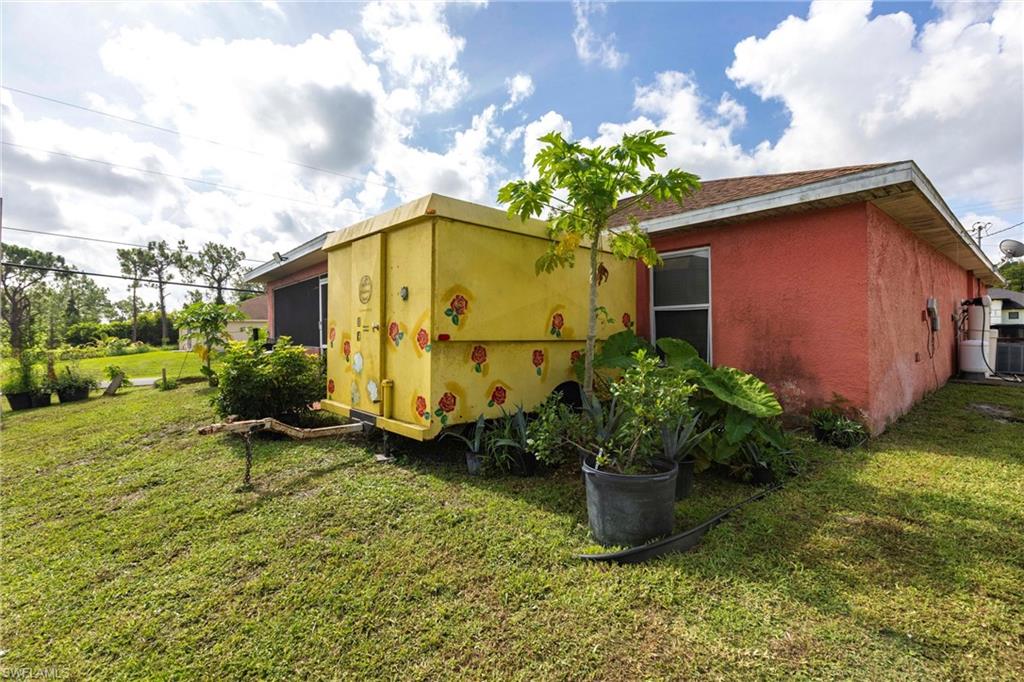 2900 8th Street Southwest Lehigh Acres, FL 33976 - Photo 32 of 32 a view of a backyard with plants and a bench