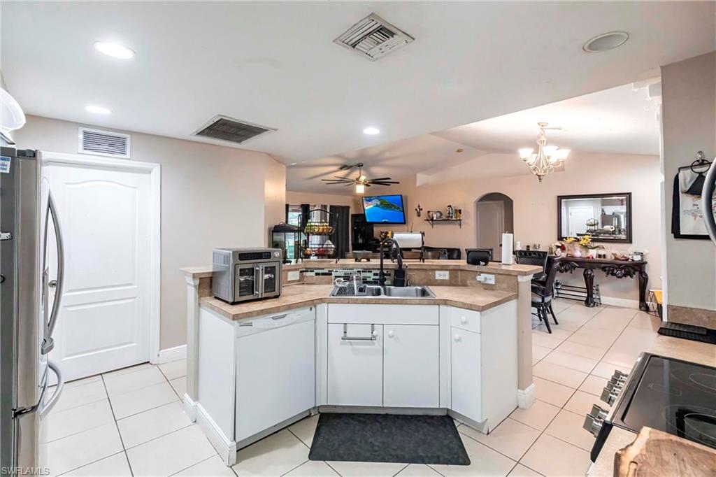2900 8th Street Southwest Lehigh Acres, FL 33976 - Photo 10 of 32 a kitchen with stainless steel appliances kitchen island granite countertop a refrigerator and a stove top oven