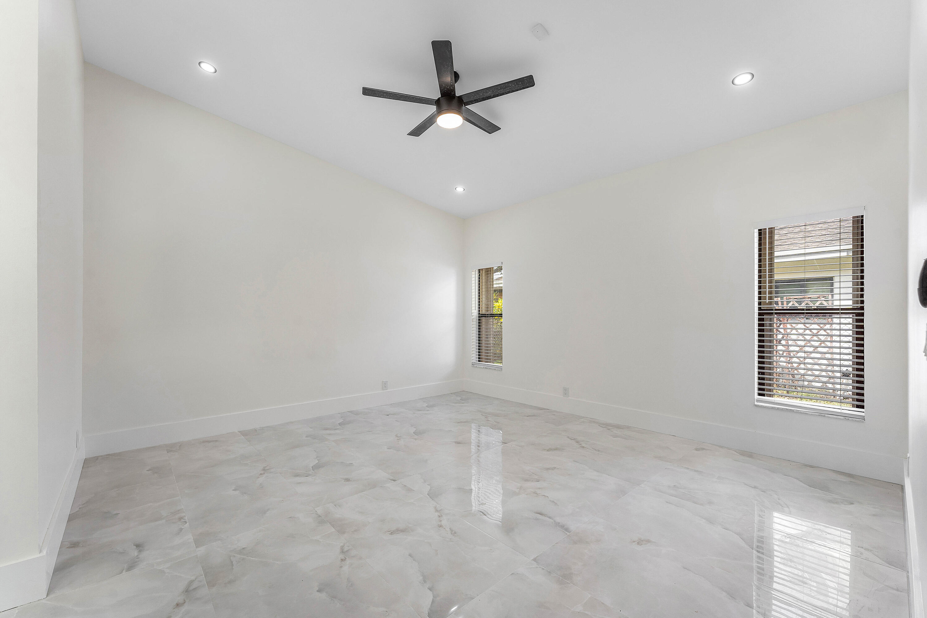 1531 Southwest 102nd Terrace Davie, FL 33324 - Photo 19 of 30 an empty room with a ceiling fan and windows