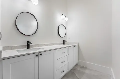 a bathroom with a double vanity sink and a mirror