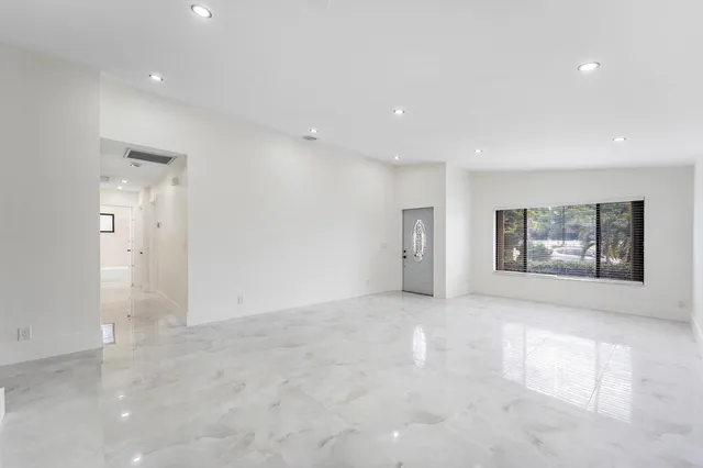 an empty room with windows and ceiling fan