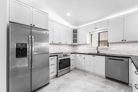 a kitchen with a refrigerator sink and cabinets