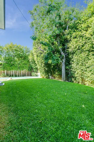 a view of a patio with table and chairs next to a yard