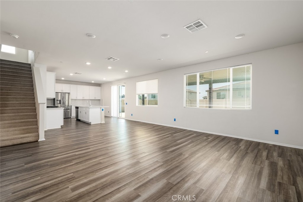 9667 Lasorda Court Riverside, CA 92503 - Photo 11 of 34 an empty room with wooden floor and windows