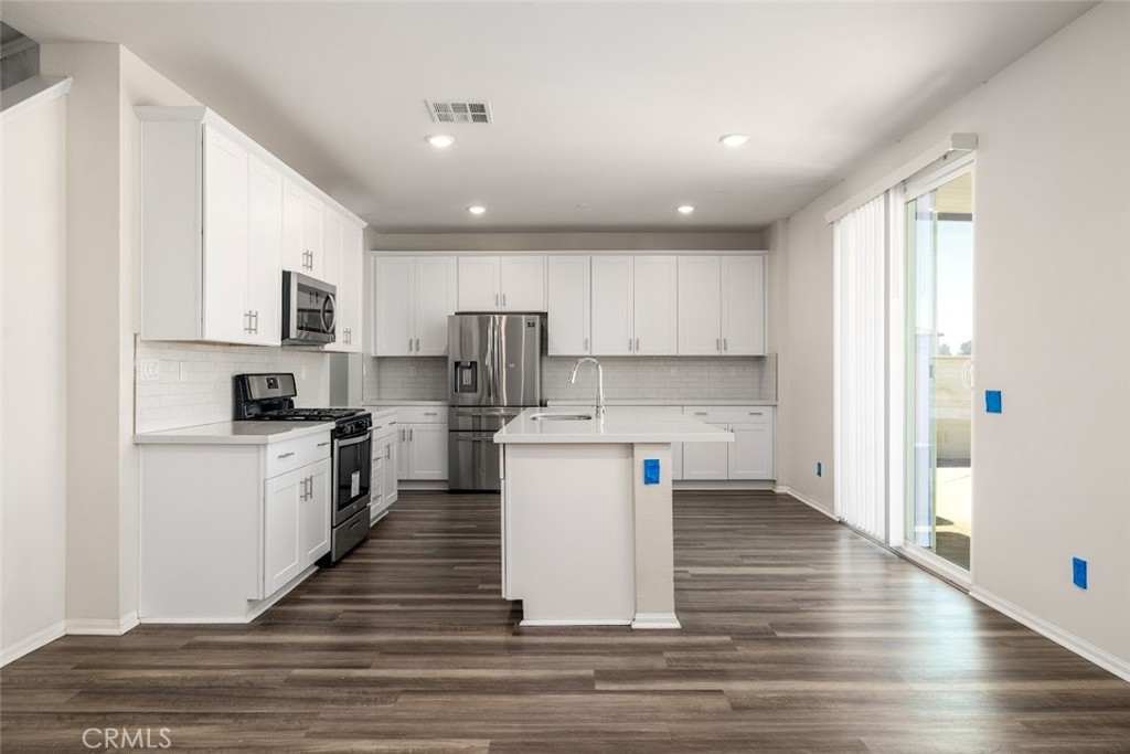 9667 Lasorda Court Riverside, CA 92503 - Photo 6 of 34 a kitchen with a refrigerator and a stove top oven