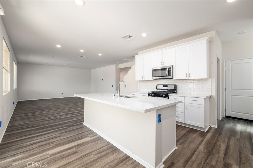9667 Lasorda Court Riverside, CA 92503 - Photo 10 of 34 a kitchen with a sink stainless steel appliances and white cabinets