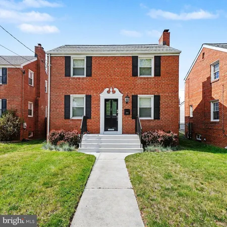 front view of a brick house with a yard