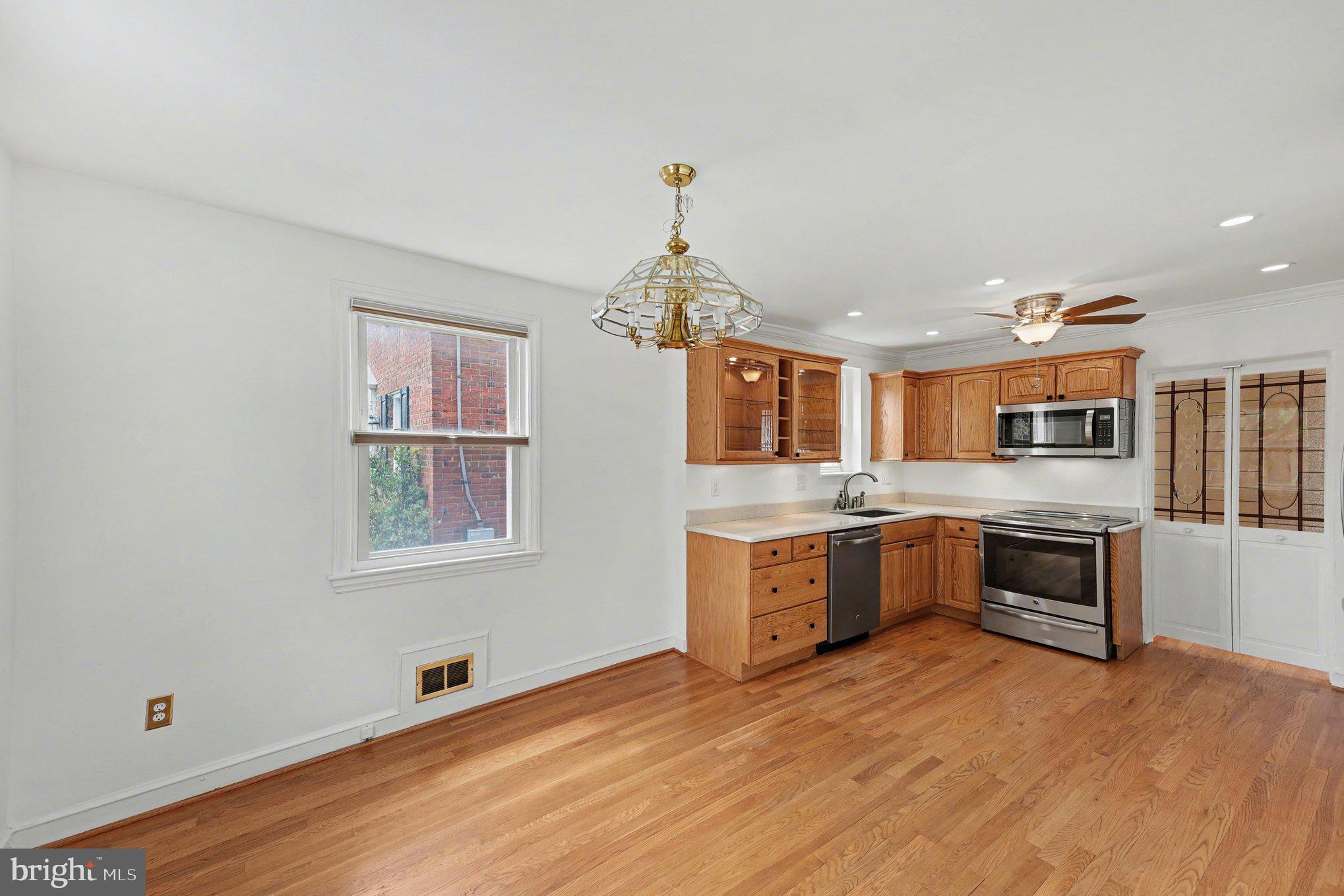 4504 20th Street Northeast Washington, DC 20018 - Photo 11 of 39 a kitchen with stainless steel appliances granite countertop a sink cabinets and wooden floor