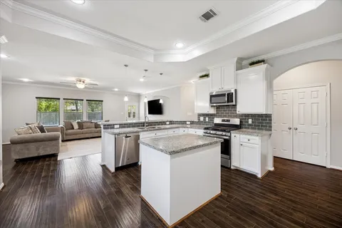 a kitchen with white cabinets and appliances