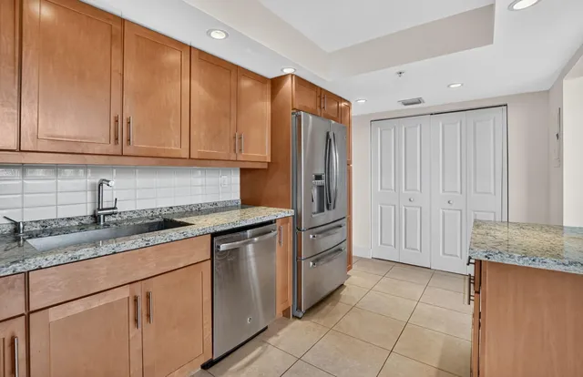 a bathroom with a granite countertop sink a toilet and shower