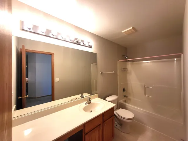 a bathroom with a sink a toilet a mirror and shower