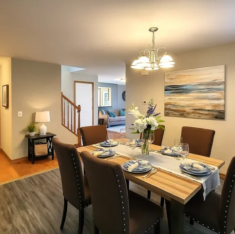 a view of a dining room with furniture a chandelier and wooden floor