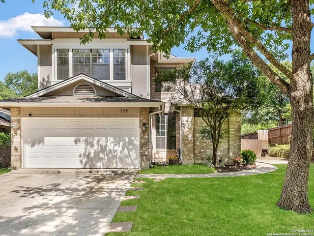 a front view of a house with a garden and a yard