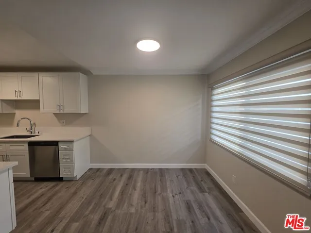 a view of a kitchen with wooden floor and a sink