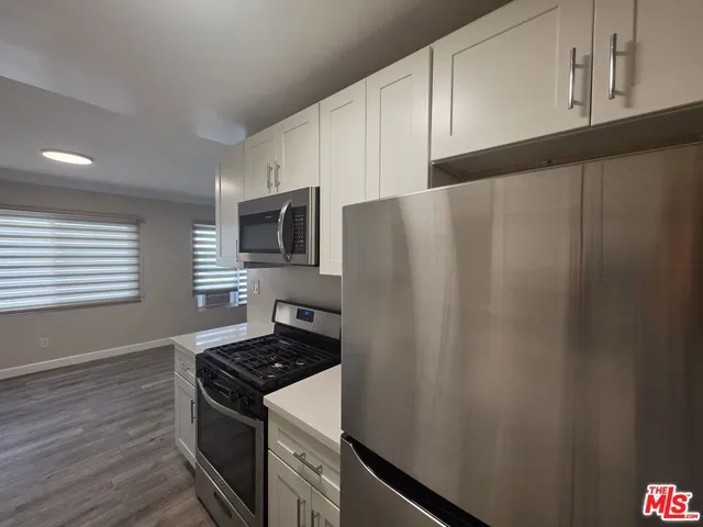 a kitchen with granite countertop cabinets stainless steel appliances and sink