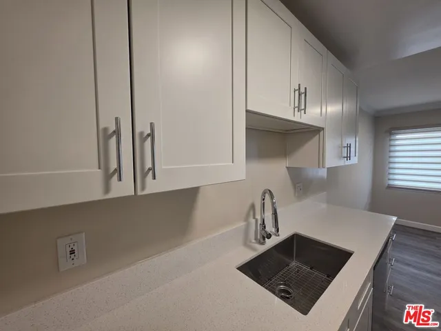 a kitchen with granite countertop a sink dishwasher stove and microwave with wooden cabinets