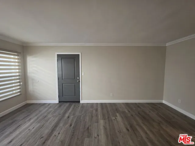 a view of a room with wooden floor and white walls