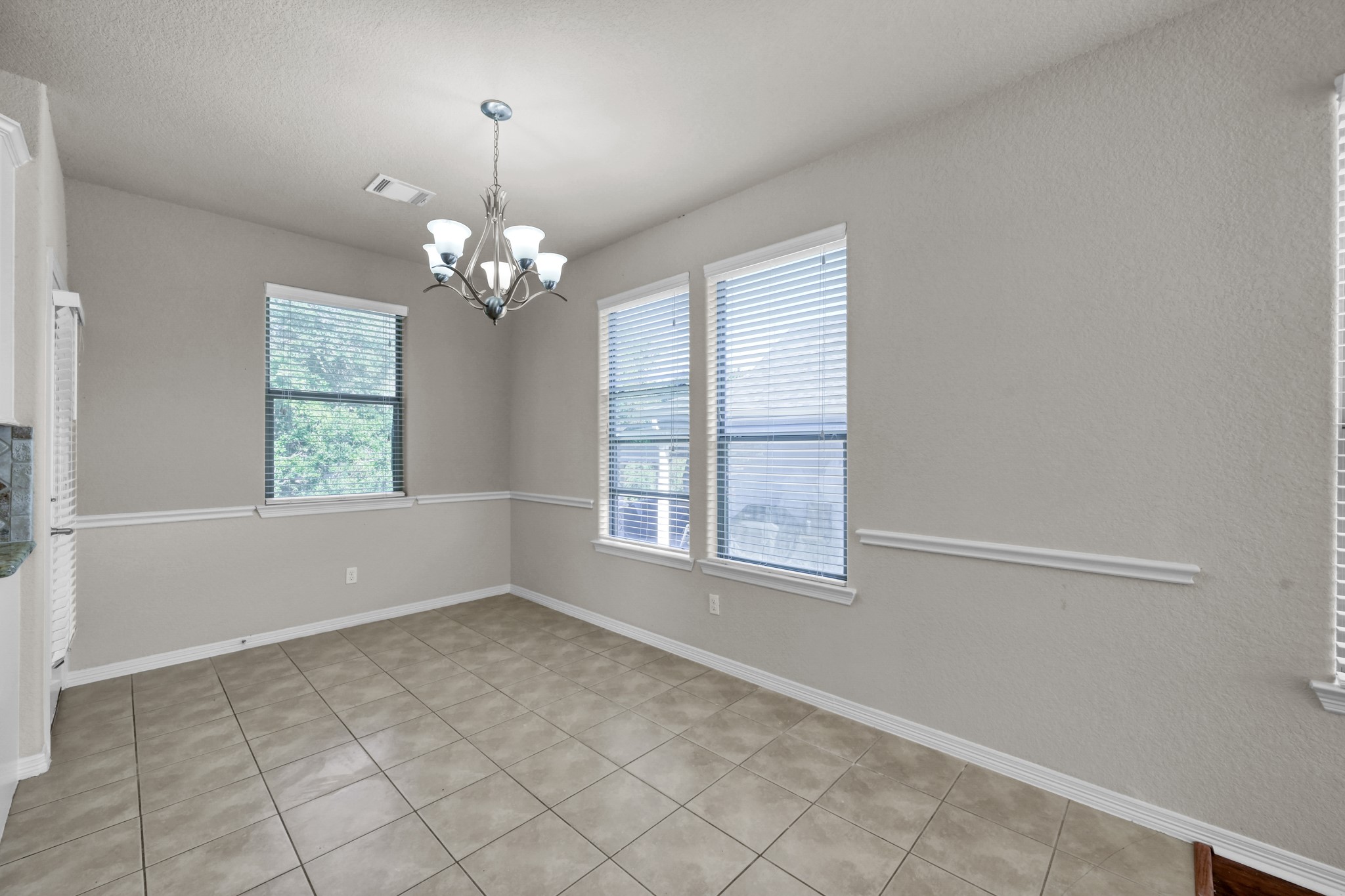 130 April Cove Conroe, TX 77356 - Photo 11 of 36 an empty room with windows and chandelier