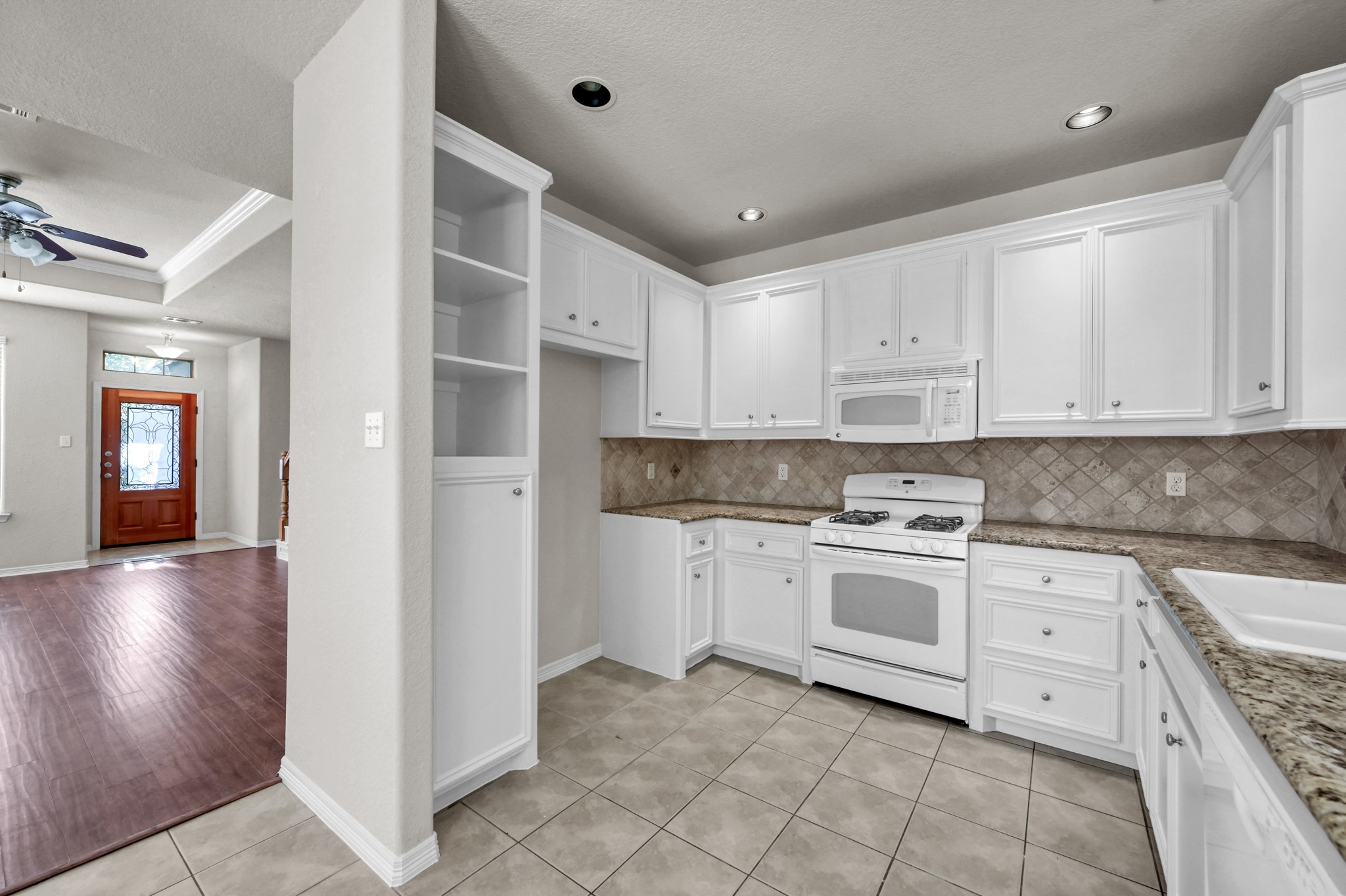 130 April Cove Conroe, TX 77356 - Photo 15 of 36 a kitchen with cabinets appliances and a sink