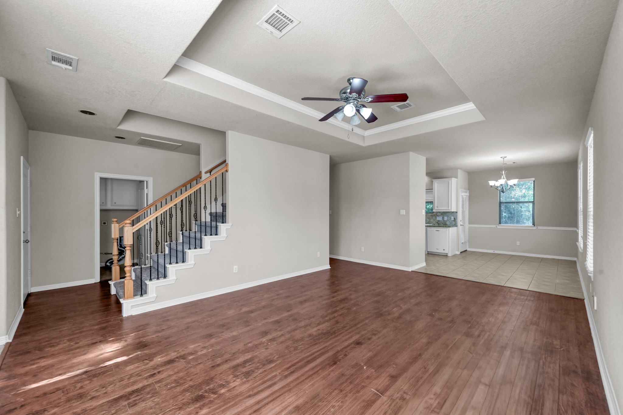 130 April Cove Conroe, TX 77356 - Photo 6 of 36 a view of an empty room with wooden floor and a ceiling fan