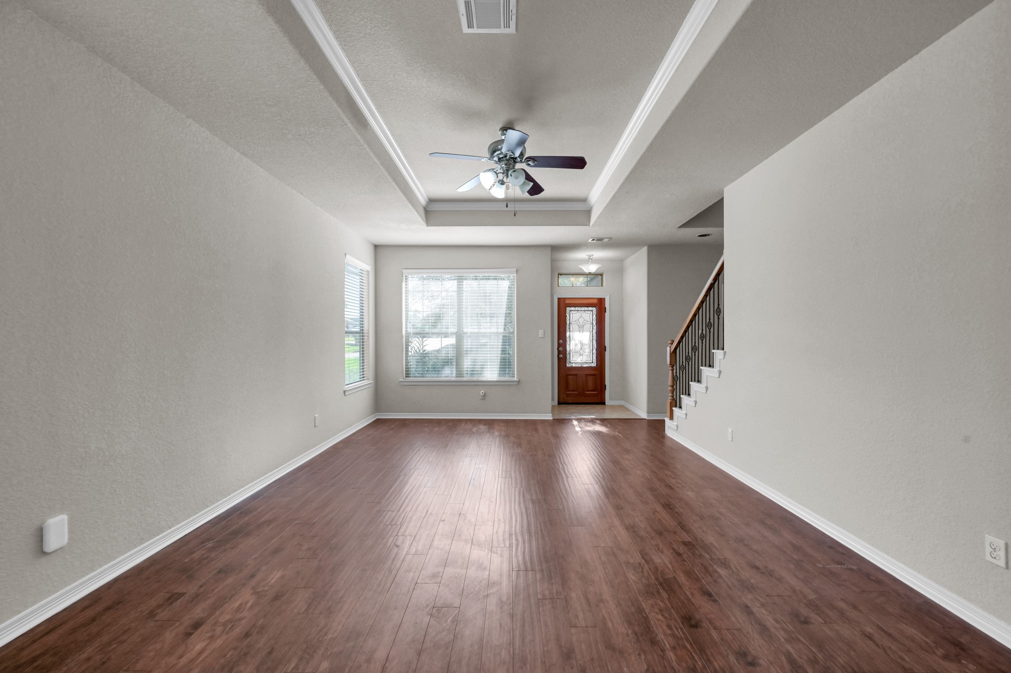130 April Cove Conroe, TX 77356 - Photo 7 of 36 an empty room with wooden floor chandelier and windows