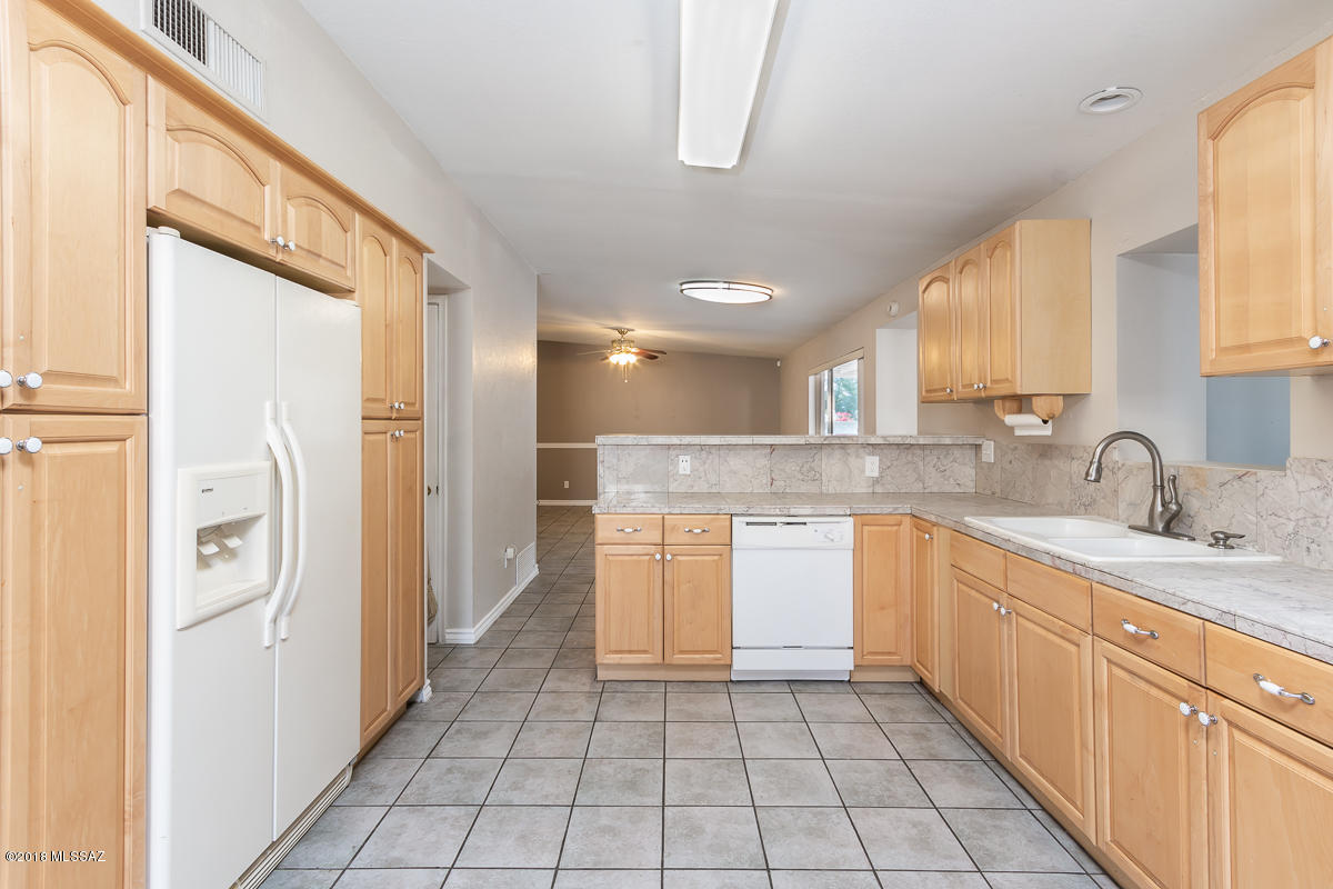 7761 North Rasmussen Avenue Tucson, AZ 85741 - Photo 6 of 23 a kitchen with a sink a refrigerator and cabinets
