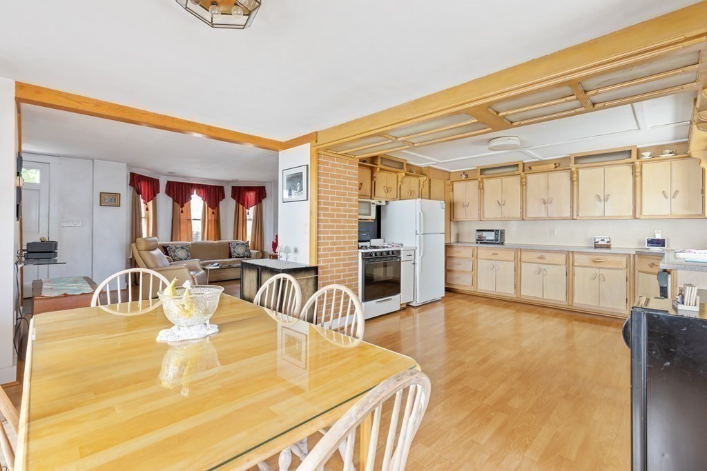 6 Harvard Street Gloucester, MA 01930 - Photo 5 of 19 a large white kitchen with wooden floor and a sink