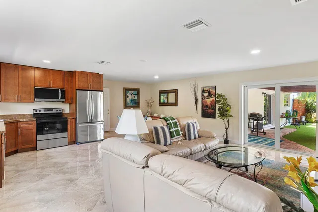 a living room with furniture a large window and kitchen view