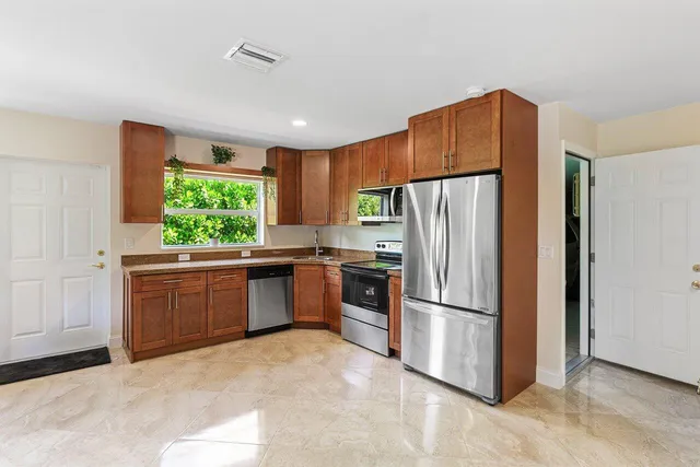 a kitchen with stainless steel appliances a refrigerator and a stove top oven
