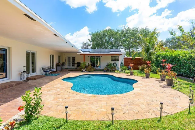 a swimming pool with outdoor seating and yard