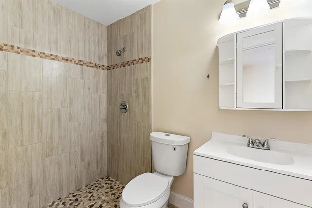 a bathroom with a sink a toilet and shower