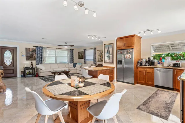 a living room with furniture a large window and stainless steel appliances