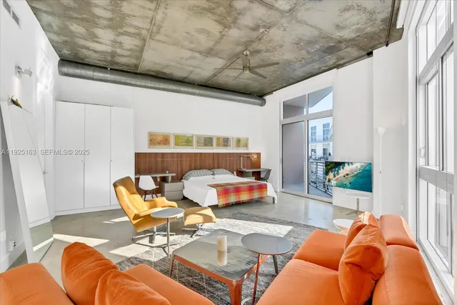 a living room with furniture a rug and a large window