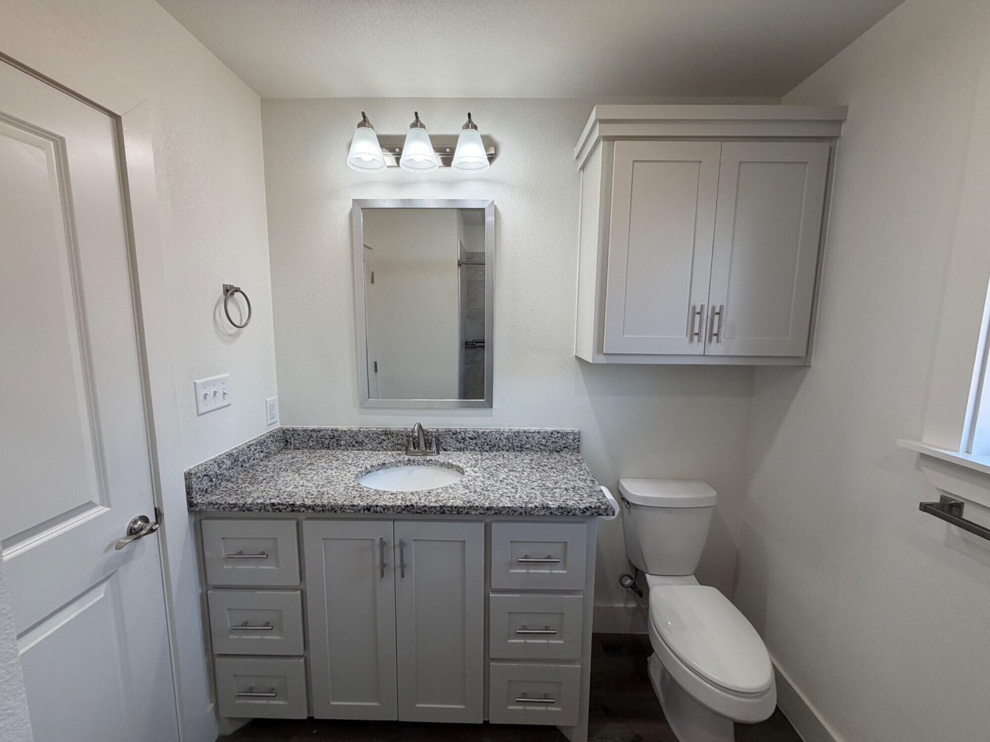 405 Ranger Street Wolfforth, TX 79382 - Photo 16 of 19 a bathroom with a granite countertop toilet sink and mirror