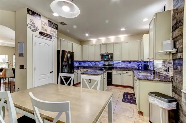 a kitchen that has a lot of cabinets a sink and a refrigerator