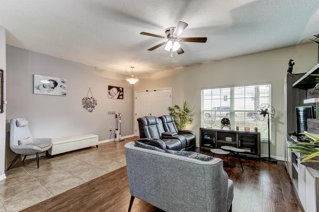 a living room with furniture a flat screen tv and a large window