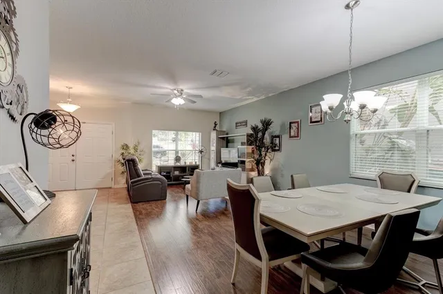 a view of a dining room with furniture a chandelier and wooden floor