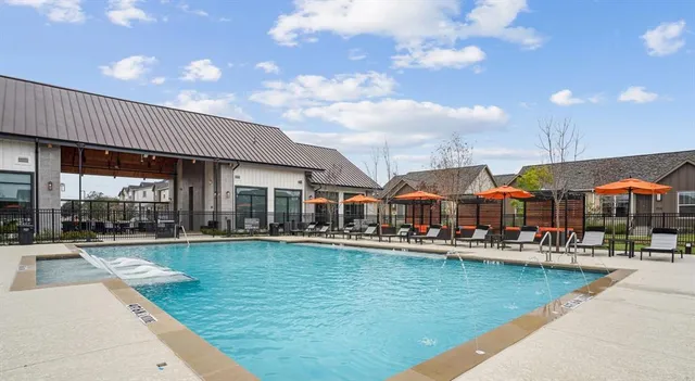 a front view of a house with swimming pool table and chairs