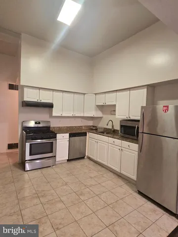a kitchen with stainless steel appliances a stove and refrigerator