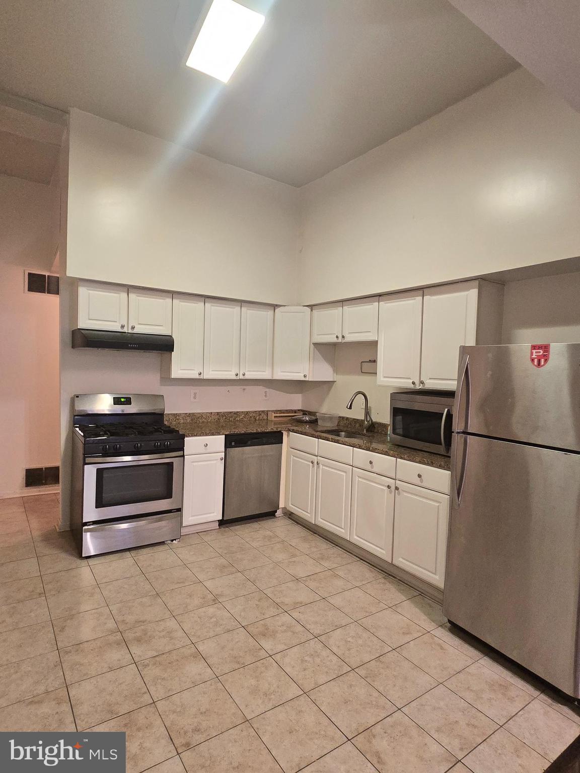 1304 Walnut Street, Unit 2 Philadelphia, PA 19107 - Photo 12 of 33 a kitchen with stainless steel appliances a stove a sink and a refrigerator