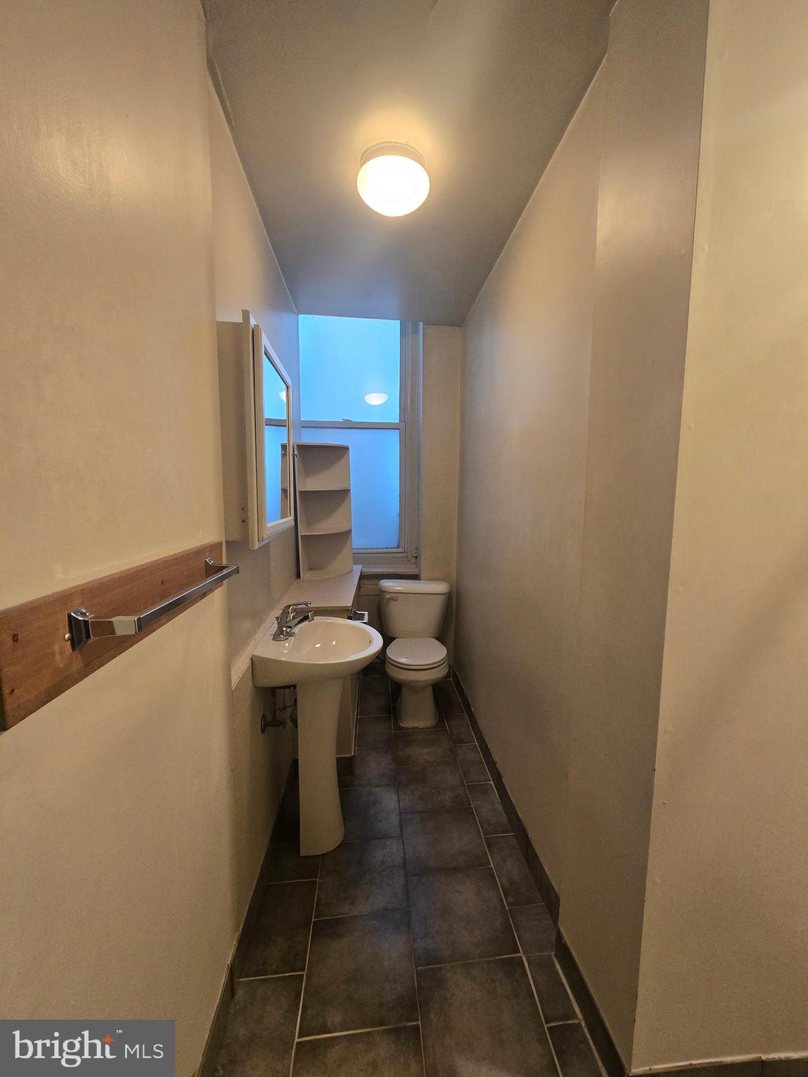 1304 Walnut Street, Unit 2 Philadelphia, PA 19107 - Photo 29 of 33 a bathroom with a sink a toilet and mirror