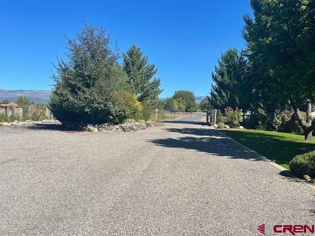 a view of road with a building and trees in the background