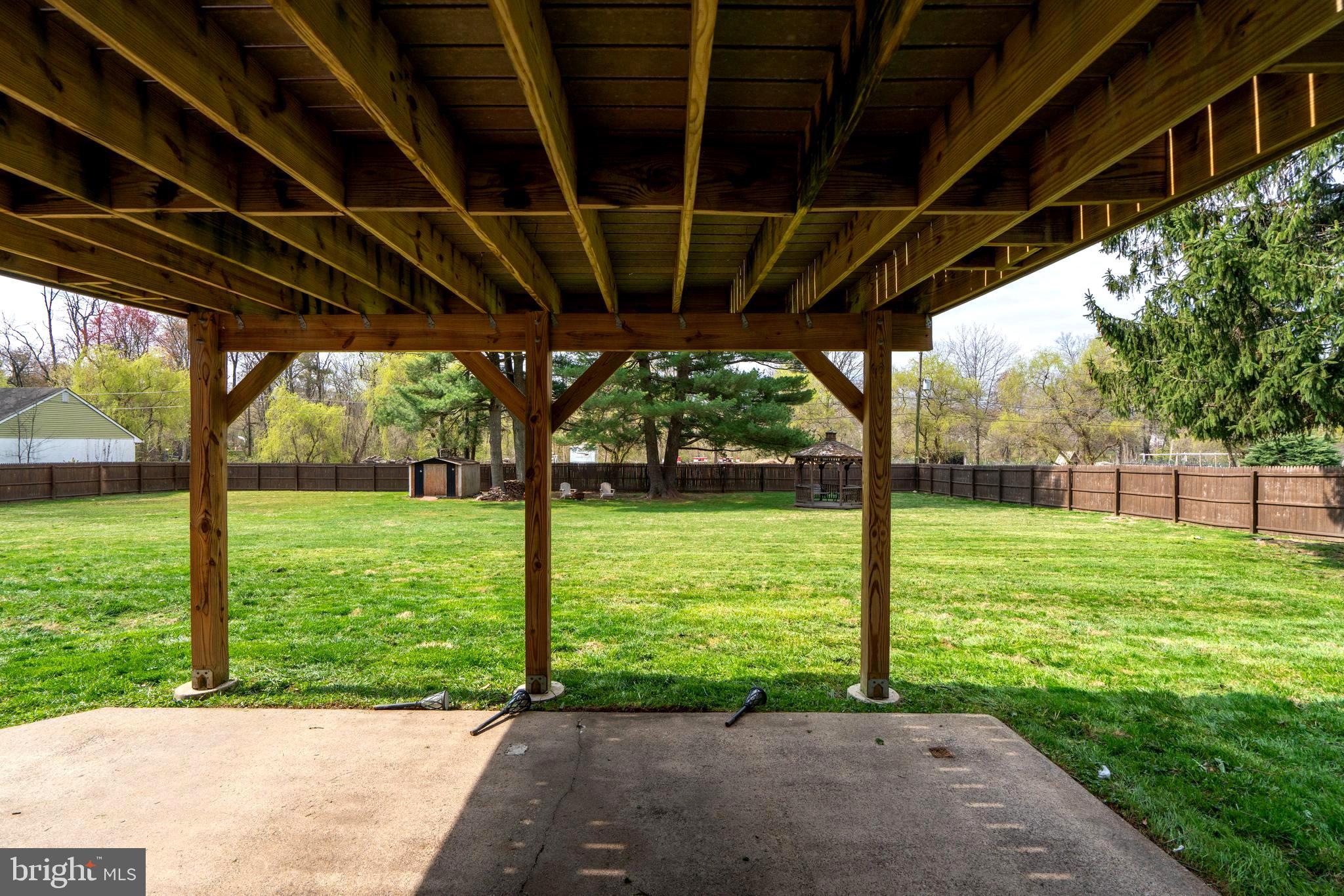 1066 Almshouse Road Ivyland, PA 18974 - Photo 34 of 39 a view of a backyard with table and chairs under an umbrella with large trees