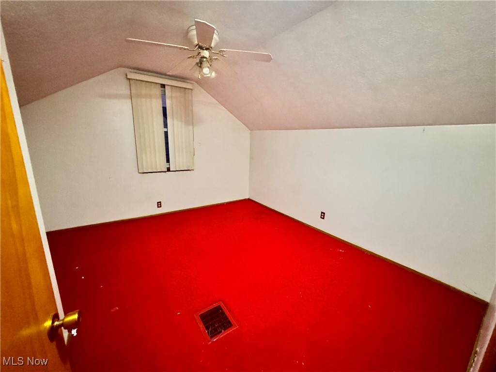 4770 Burleigh Road Cleveland, OH 44125 - Photo 14 of 22 Bonus room with vaulted ceiling and carpet flooring