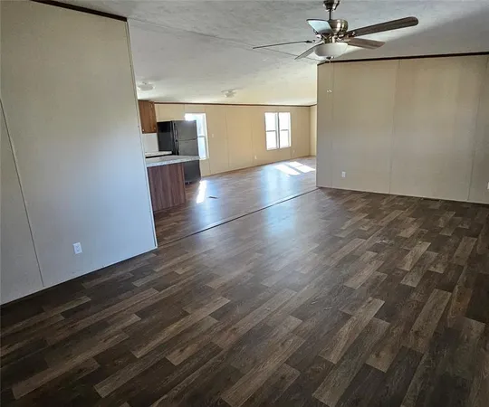 a view of a kitchen with a sink cabinet a microwave and refrigerator