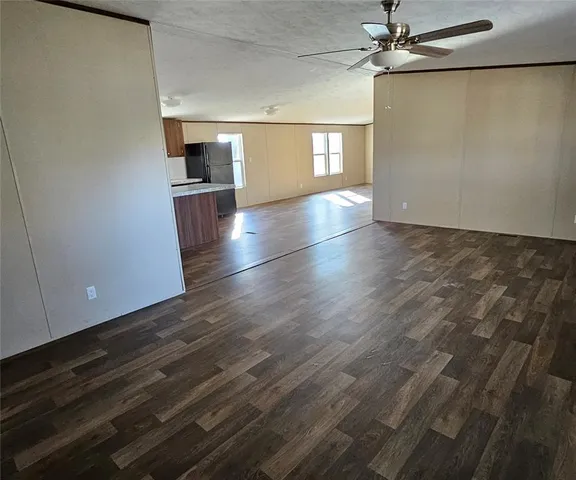 a view of a kitchen with a sink cabinet a microwave and refrigerator
