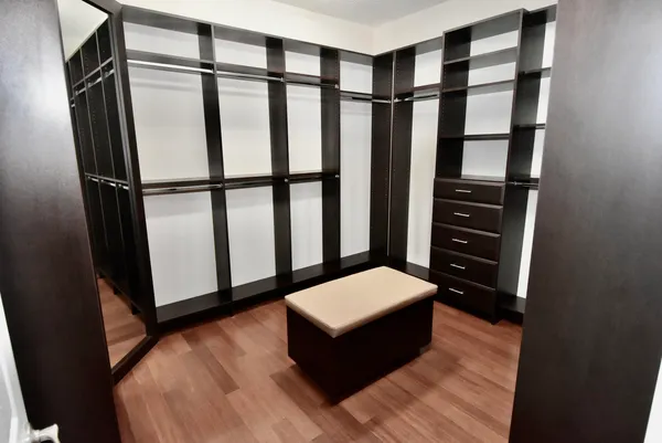 a view of walk in closet with clothes and shoes