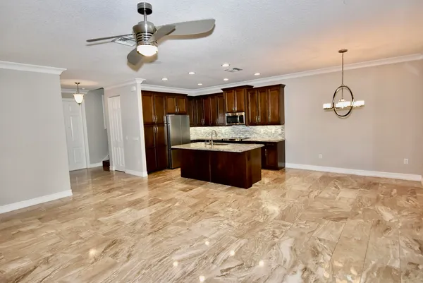 a view of kitchen with granite countertop cabinets and refrigerator